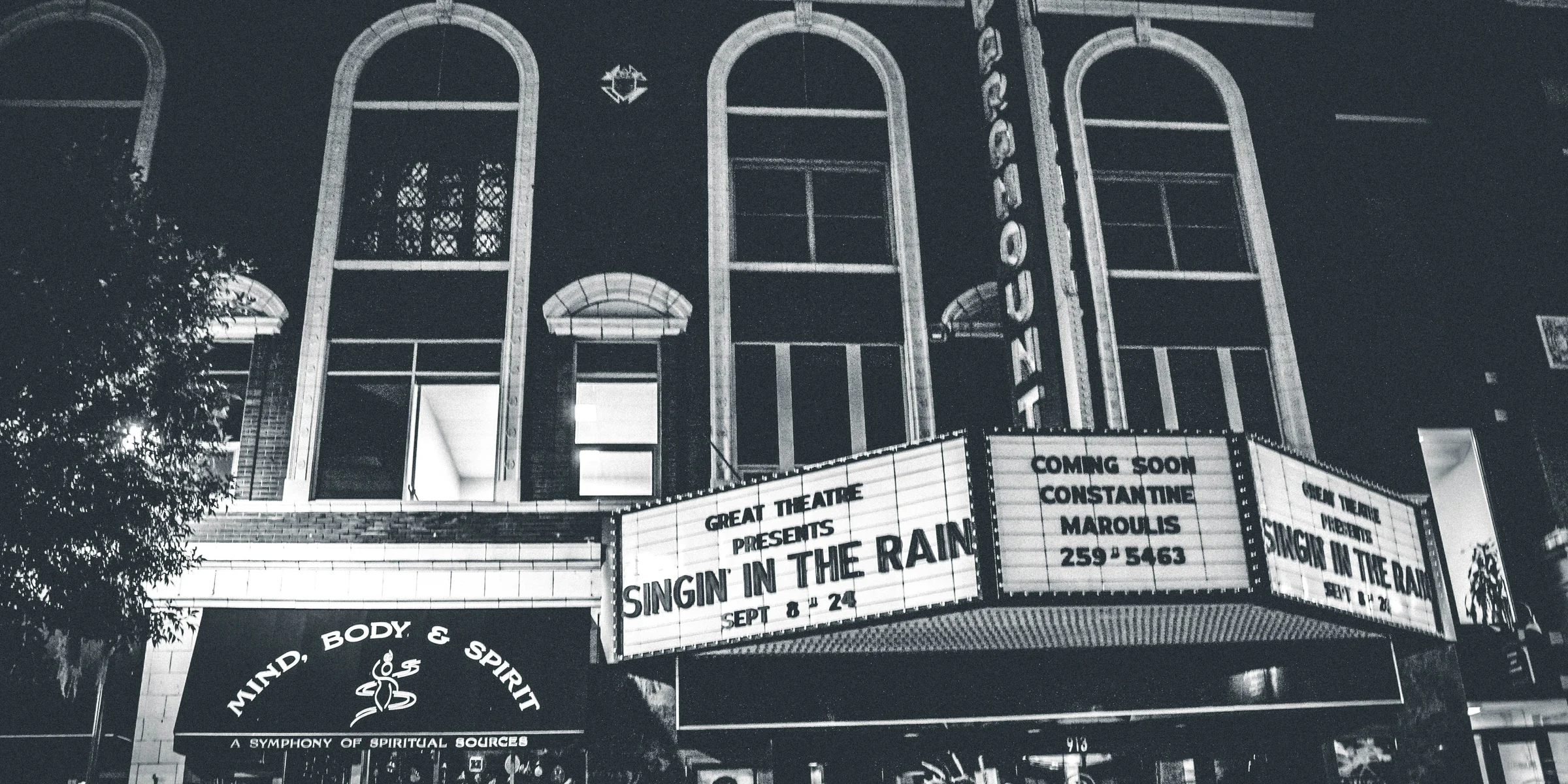 grayscale photo of theater hall with Singin in the Rain movie