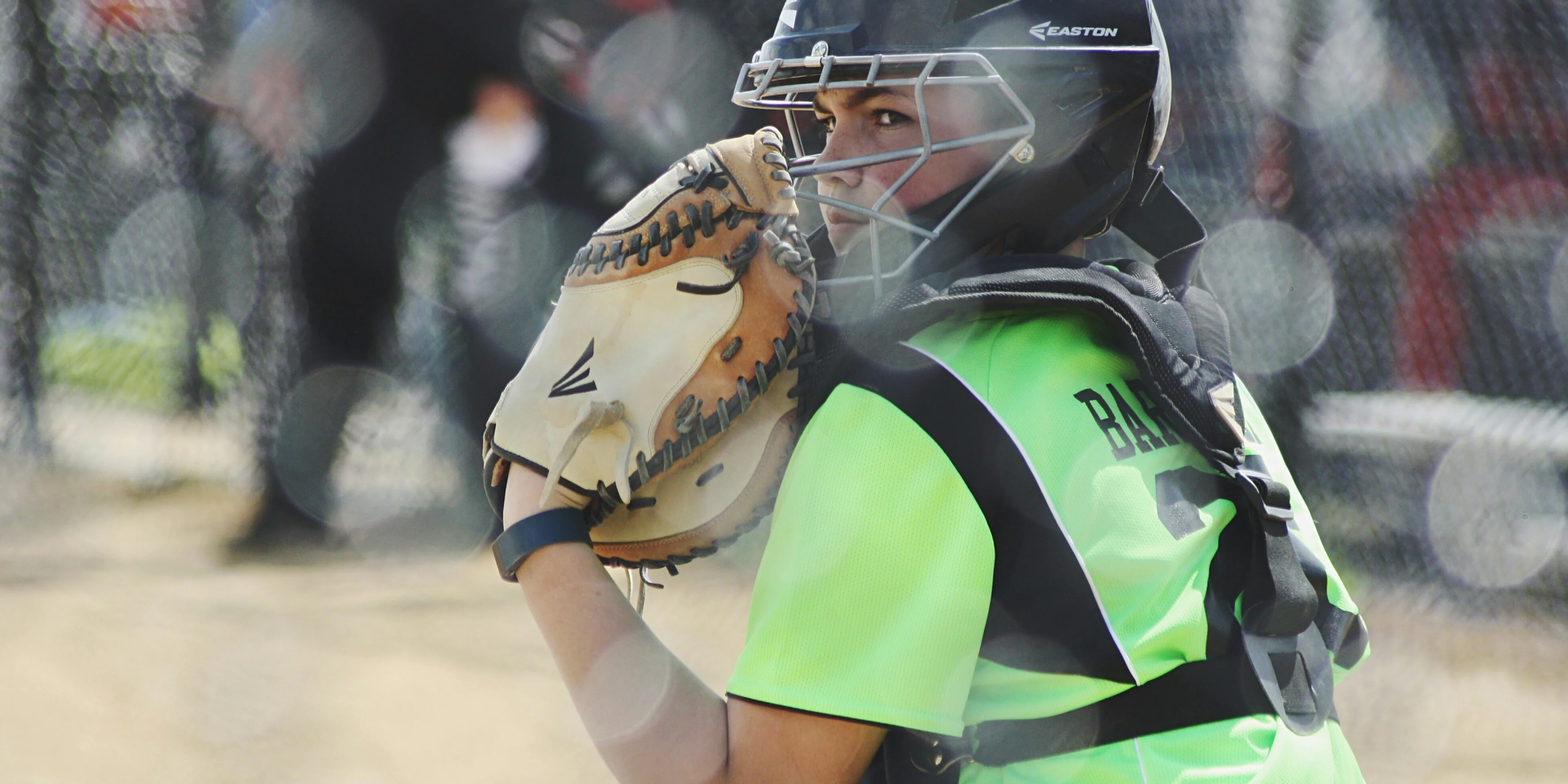 woman wearing brown Easton baseball mitt playing baseball.