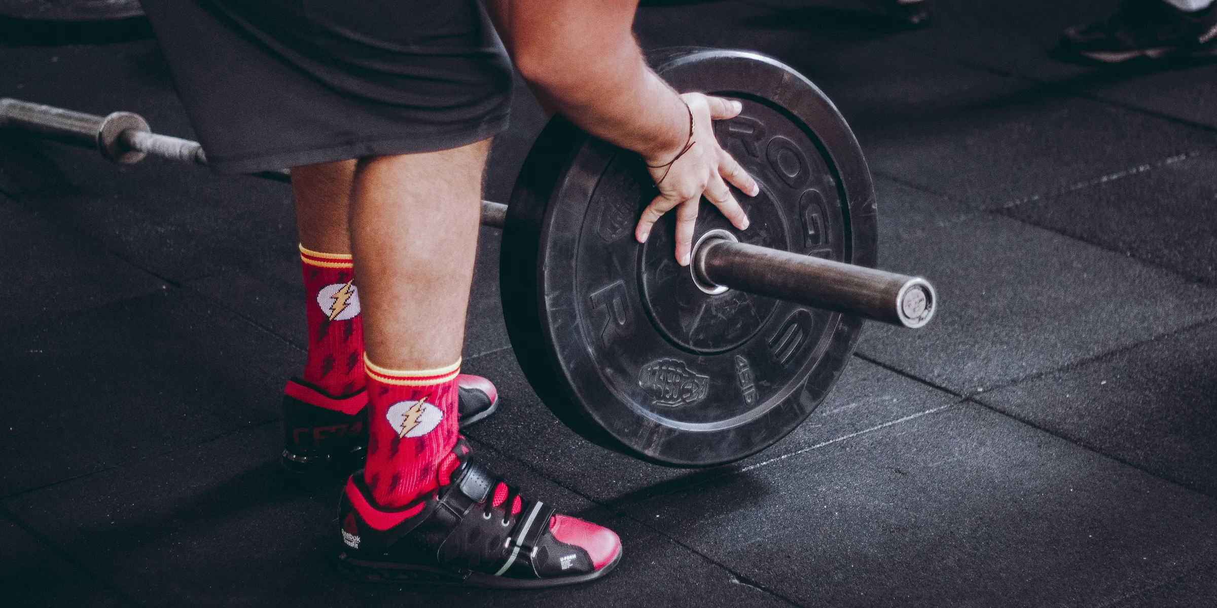 person arranging barbell plate.