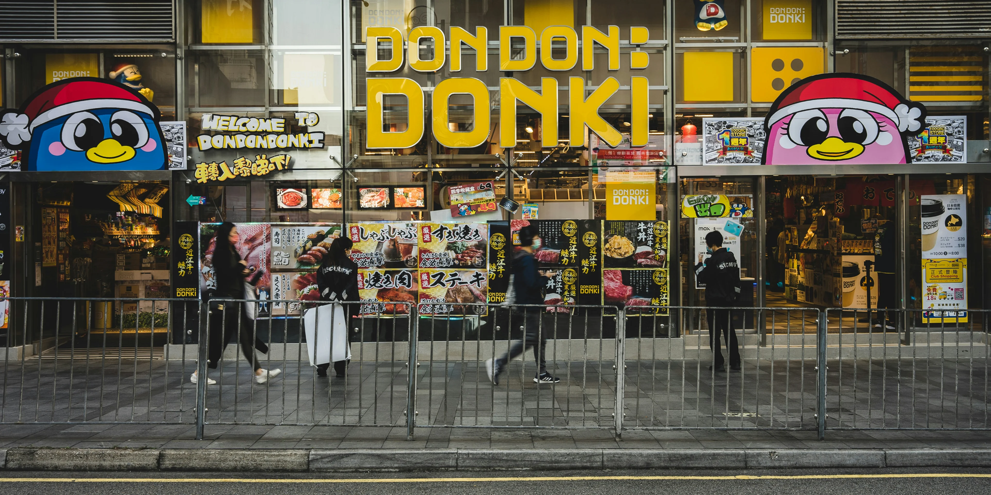 a store front with people walking by on the sidewalk.