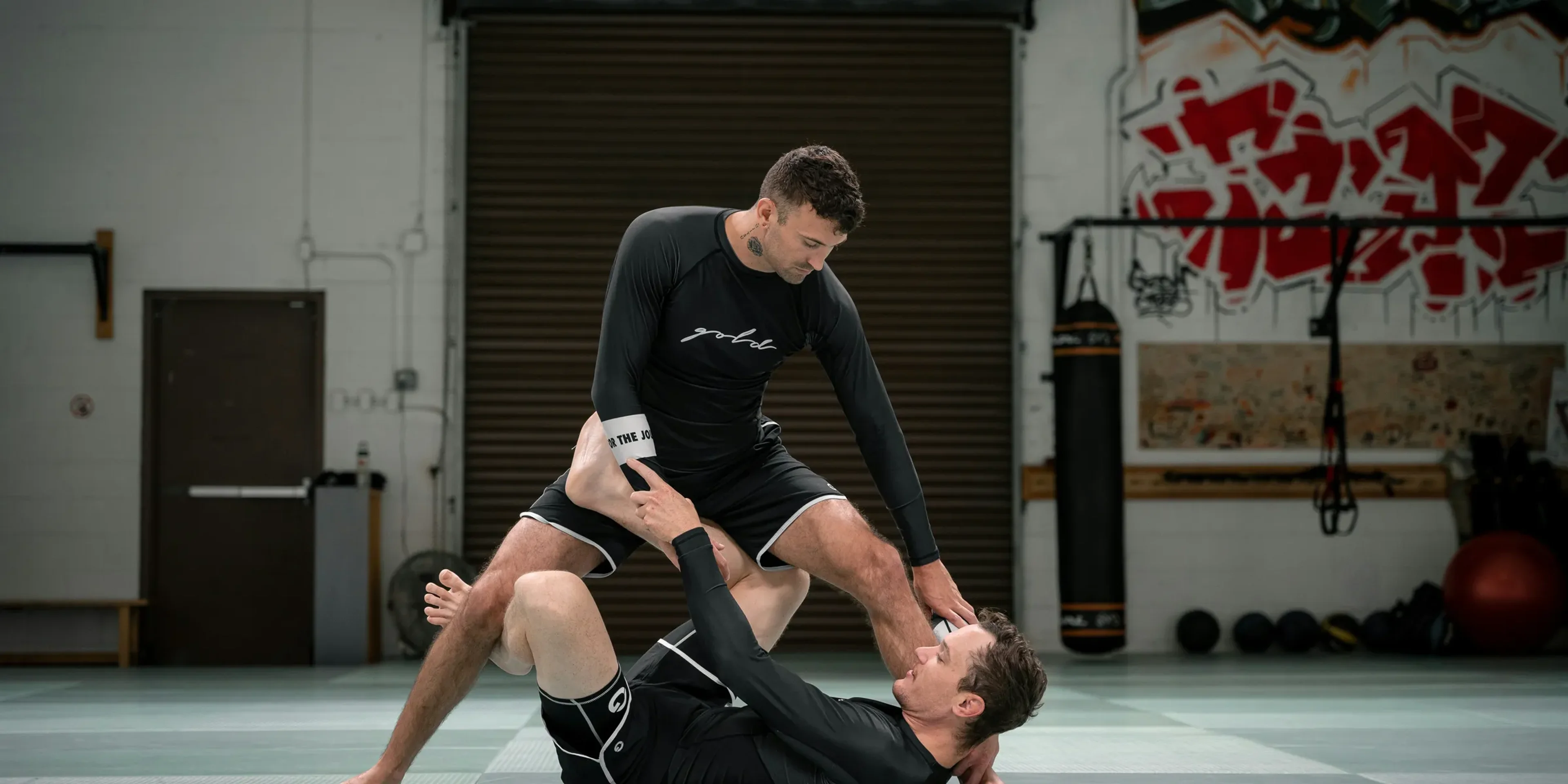 a couple of men standing on top of each other in a gym