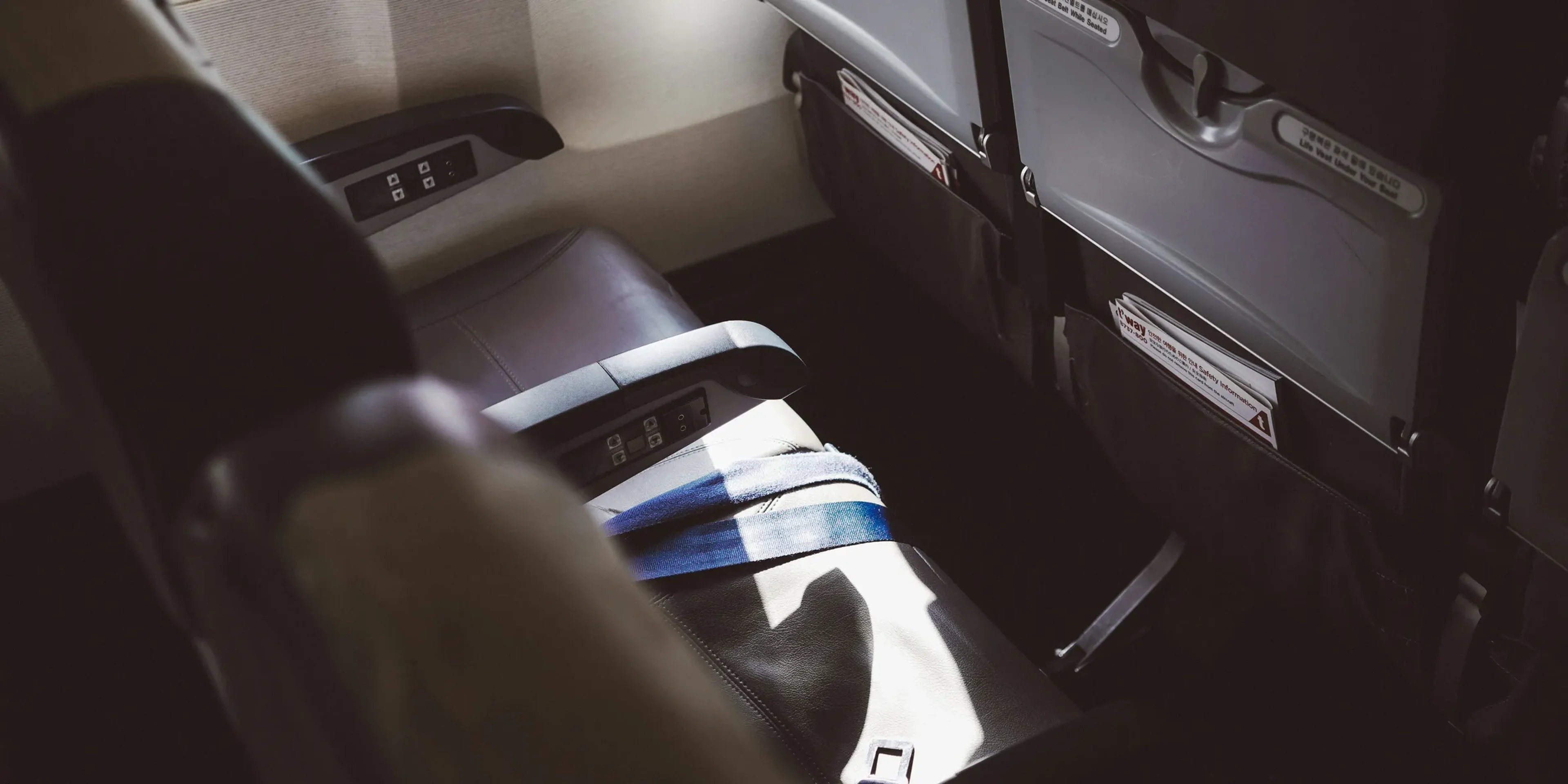 person in blue white and black shorts sitting on car seat