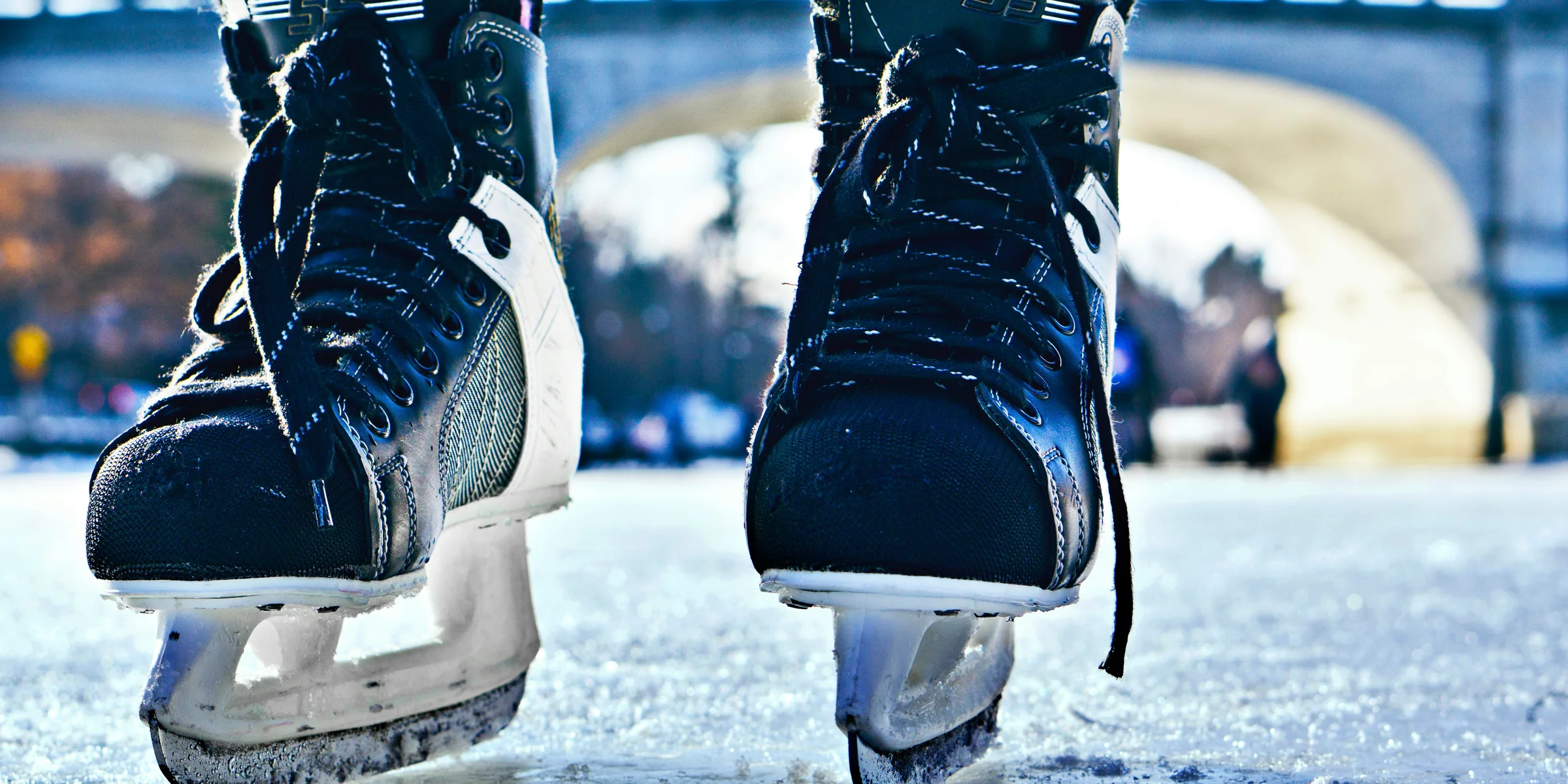 close-up photo of black-and-gray Intruder ice skates on frozen body of water