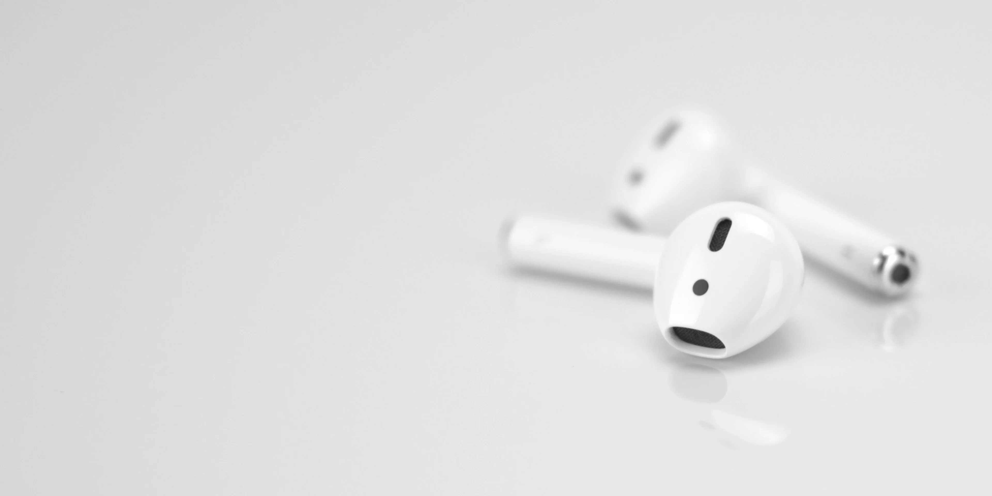 Apple AirPods on white surface