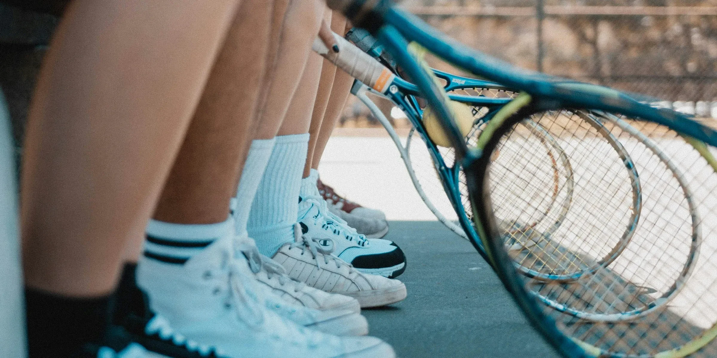 person wearing white and black adidas sneakers