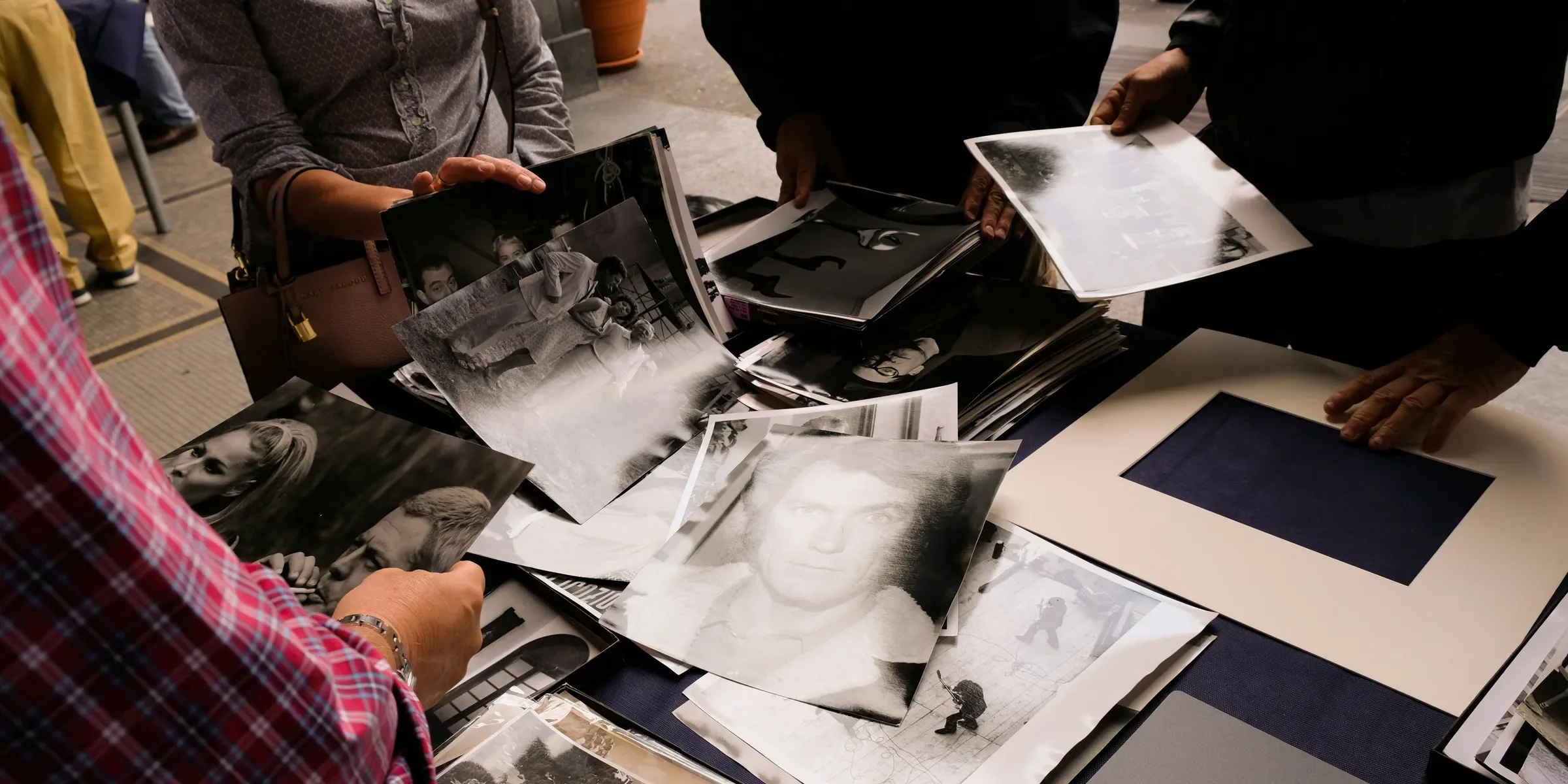 people standing near table holding photos