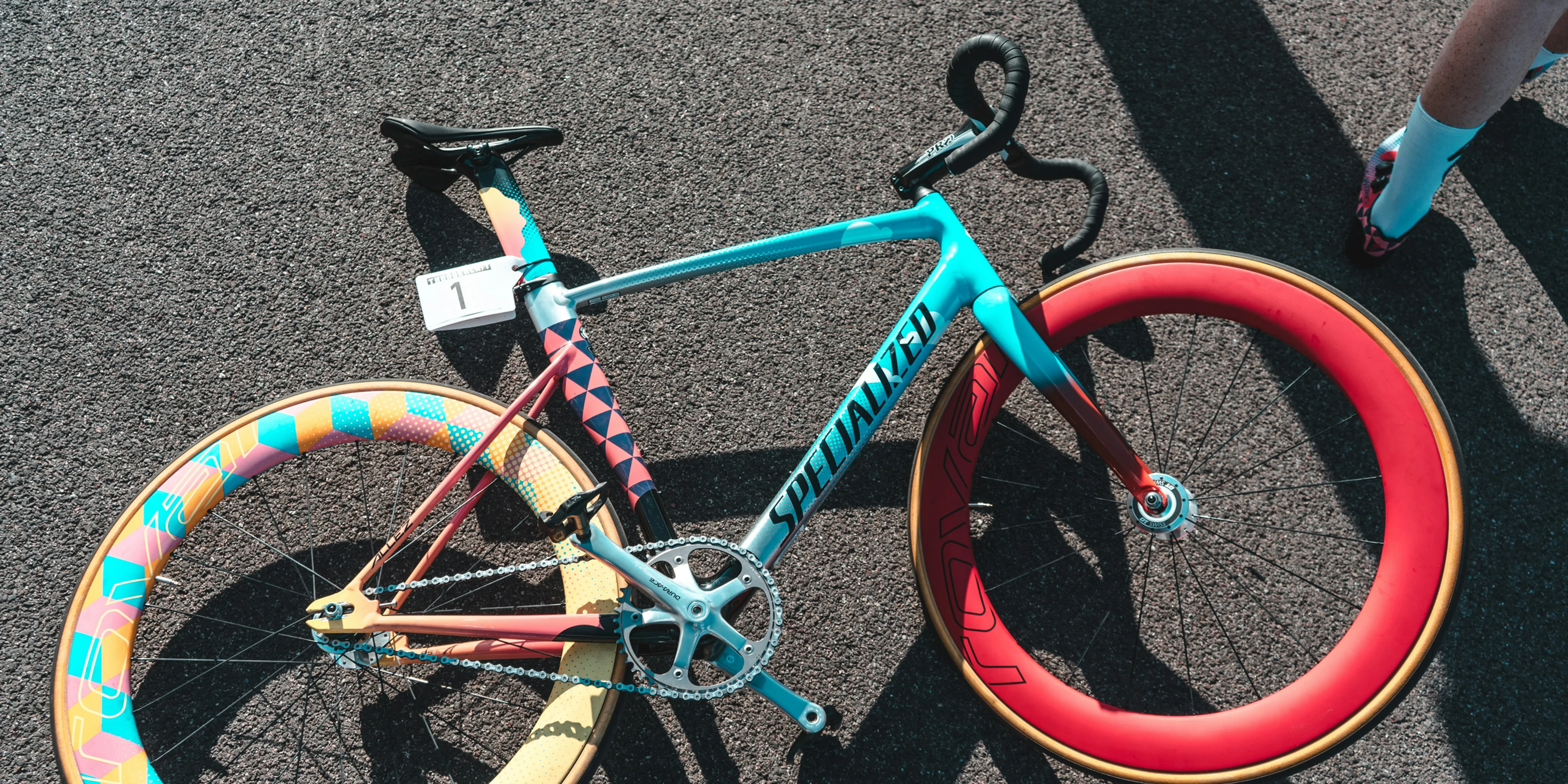 blue and red Specialized fixie bike on grey surface.