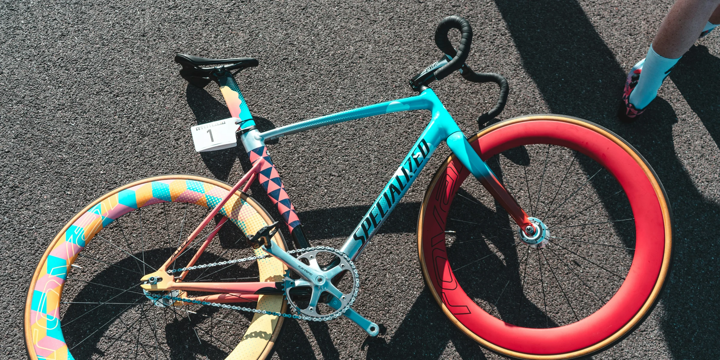 blue and red Specialized fixie bike on grey surface.