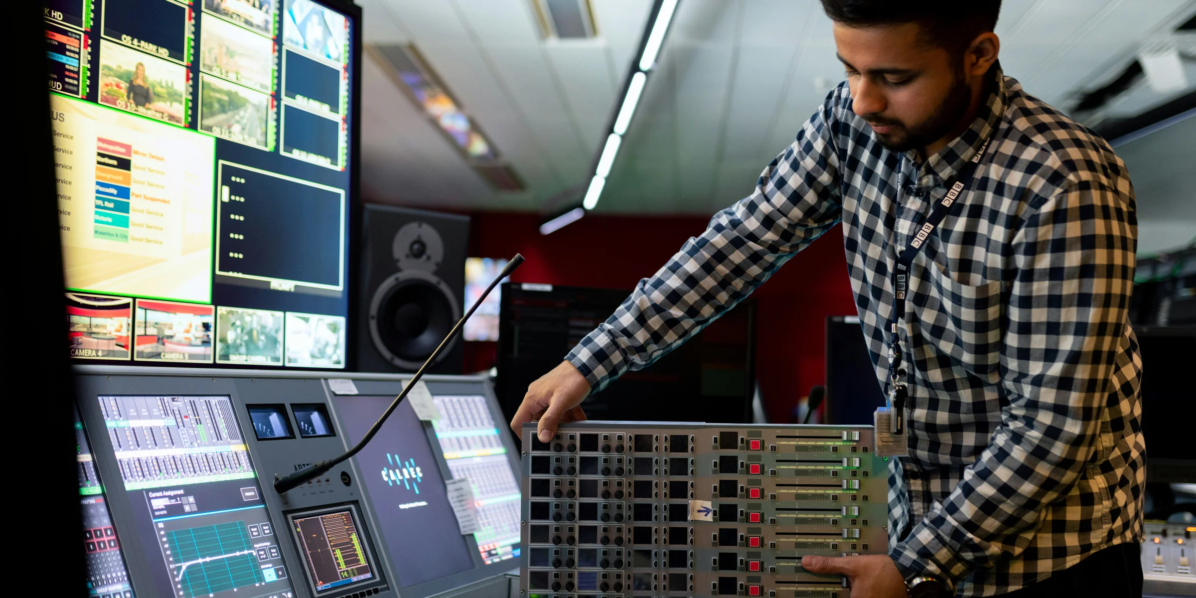 man in black and white checkered dress shirt playing dj controller.