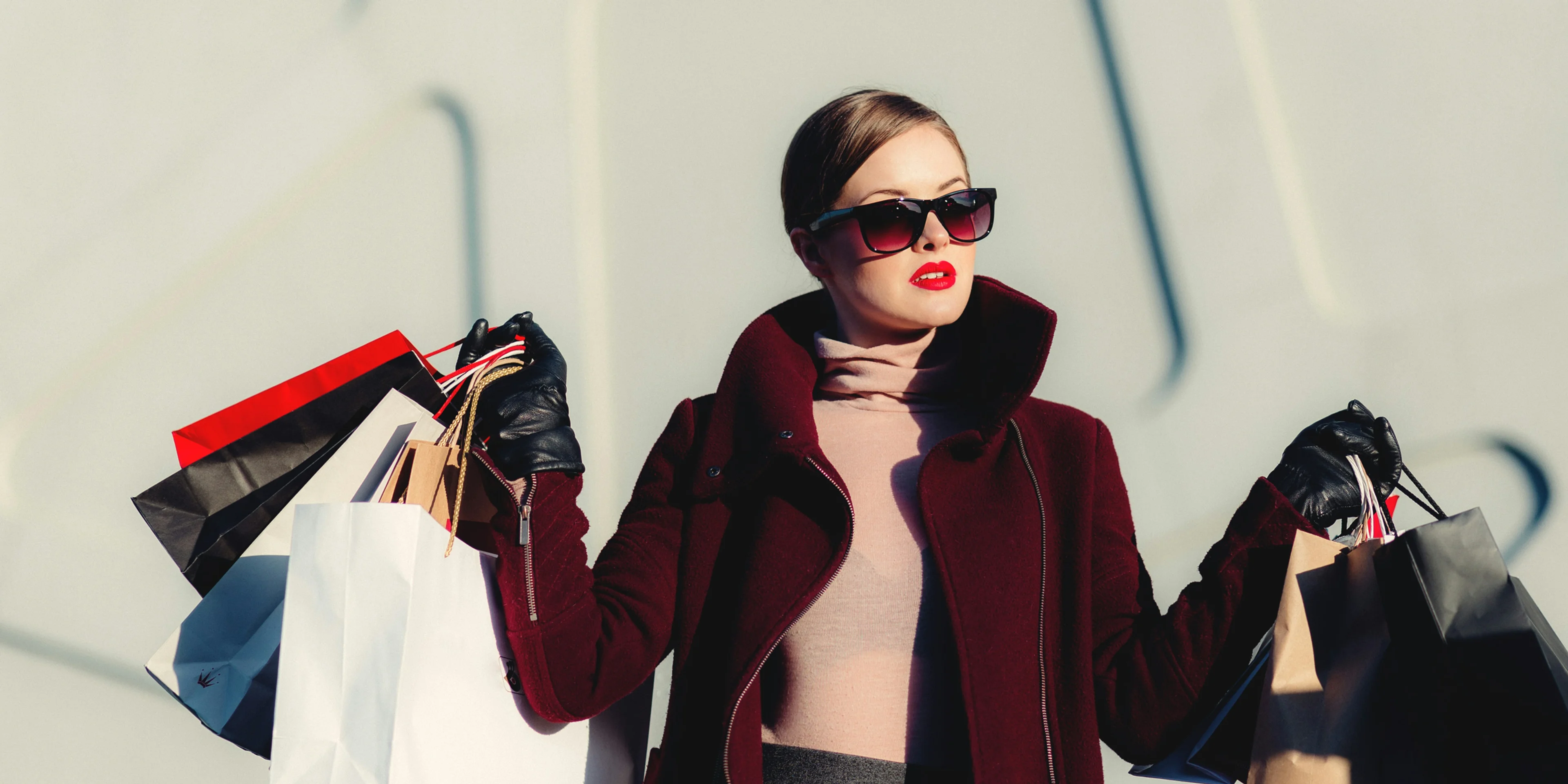 photo of woman holding white and black paper bags.