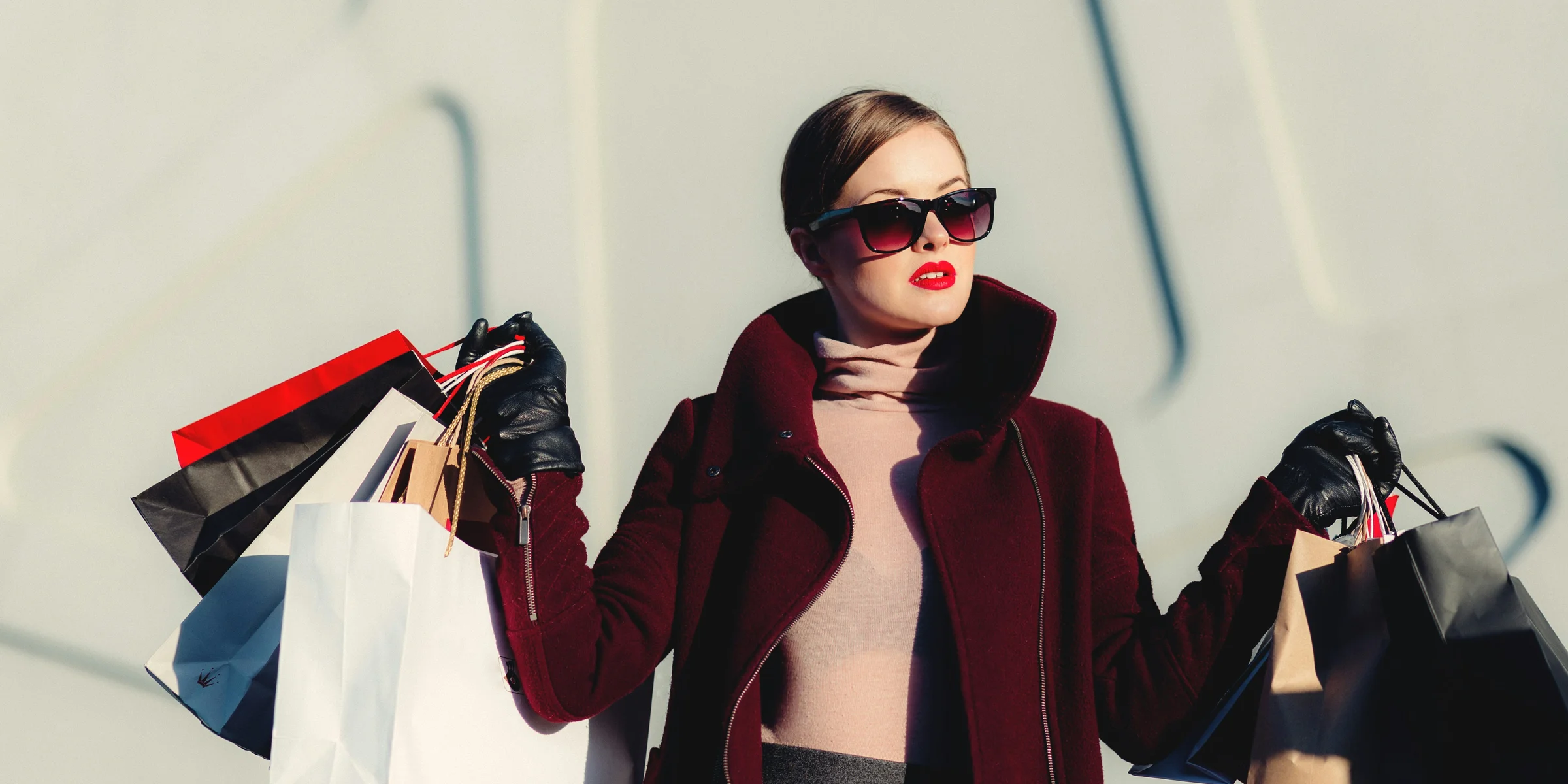 photo of woman holding white and black paper bags.