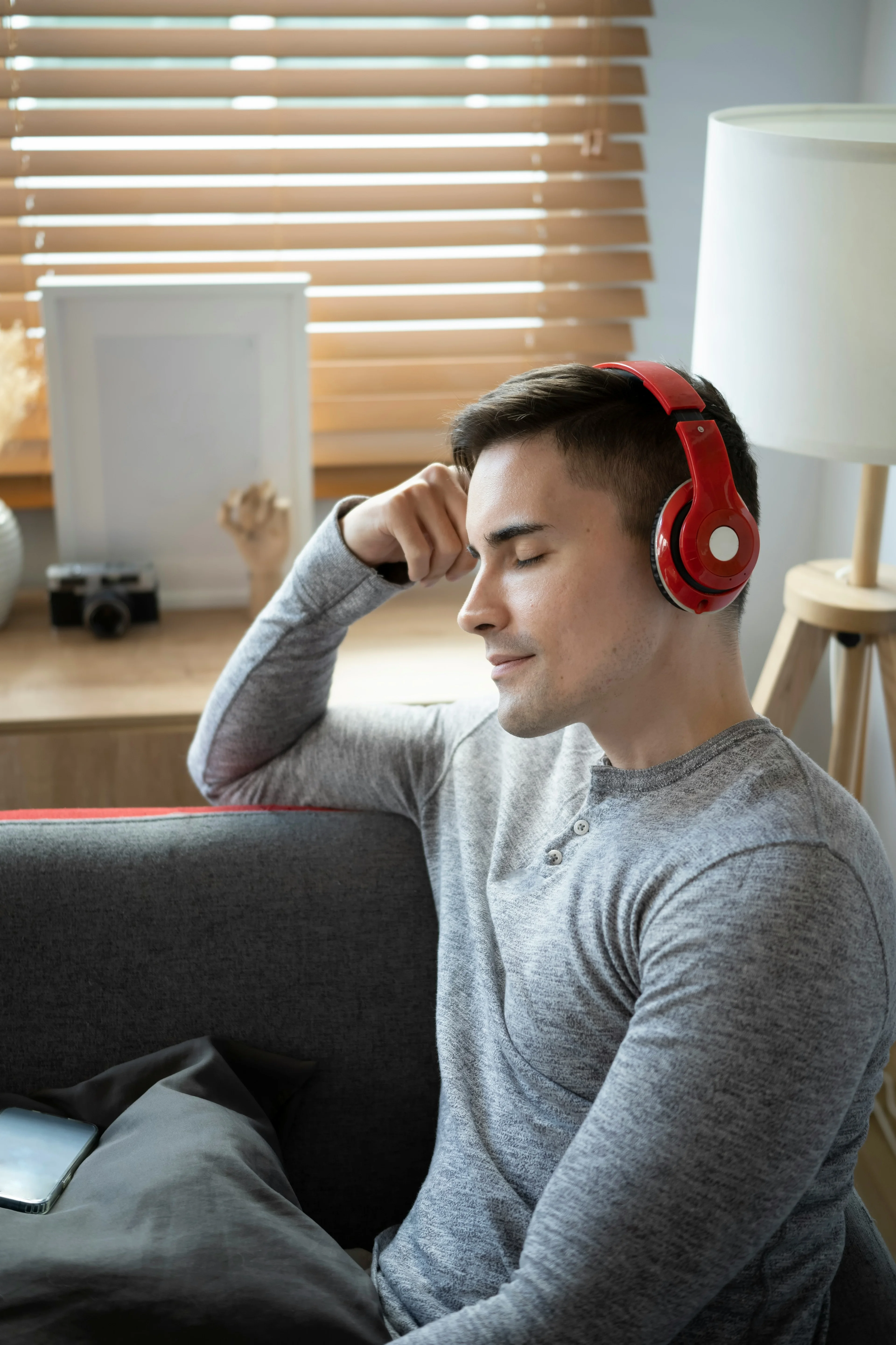 man on couch listening to music with headphones