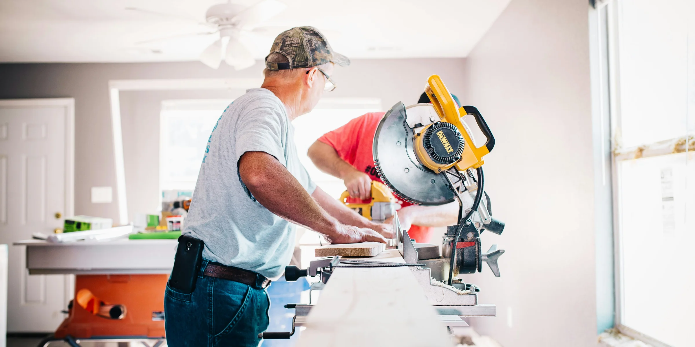 man standing infront of miter saw.