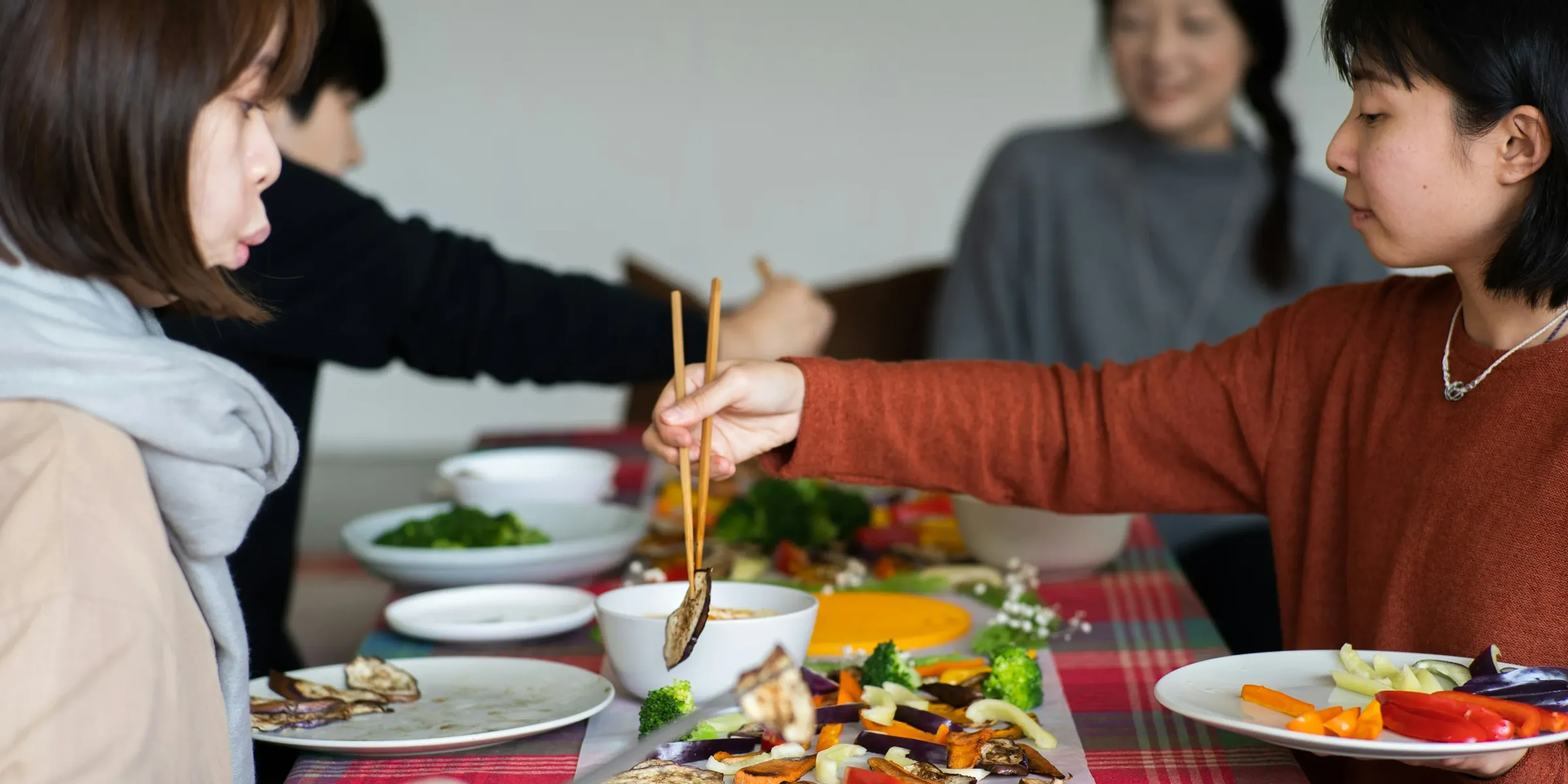 a group of women sitting around a table eating food