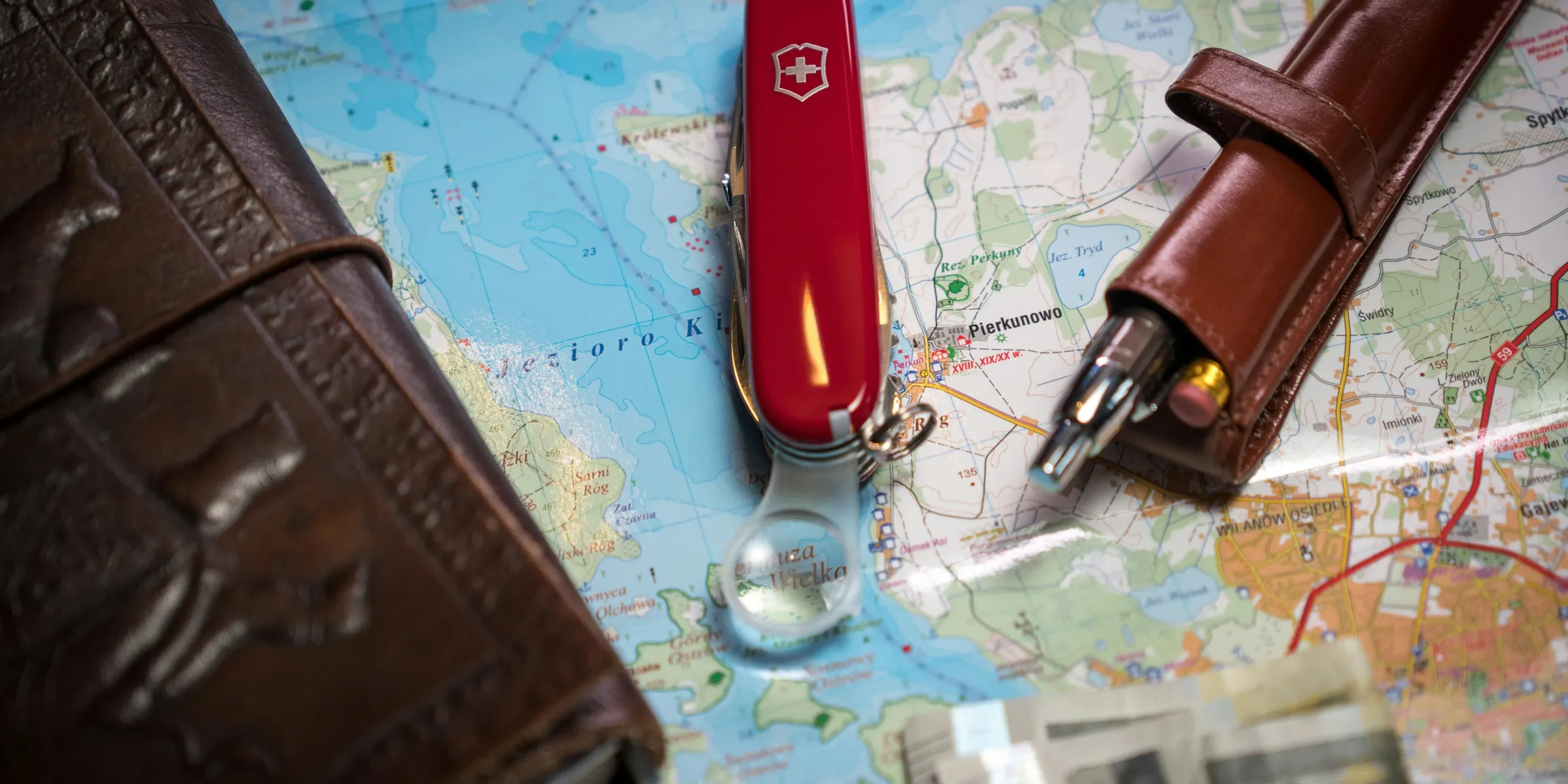 A map with a pen, wallet, and a knife on it