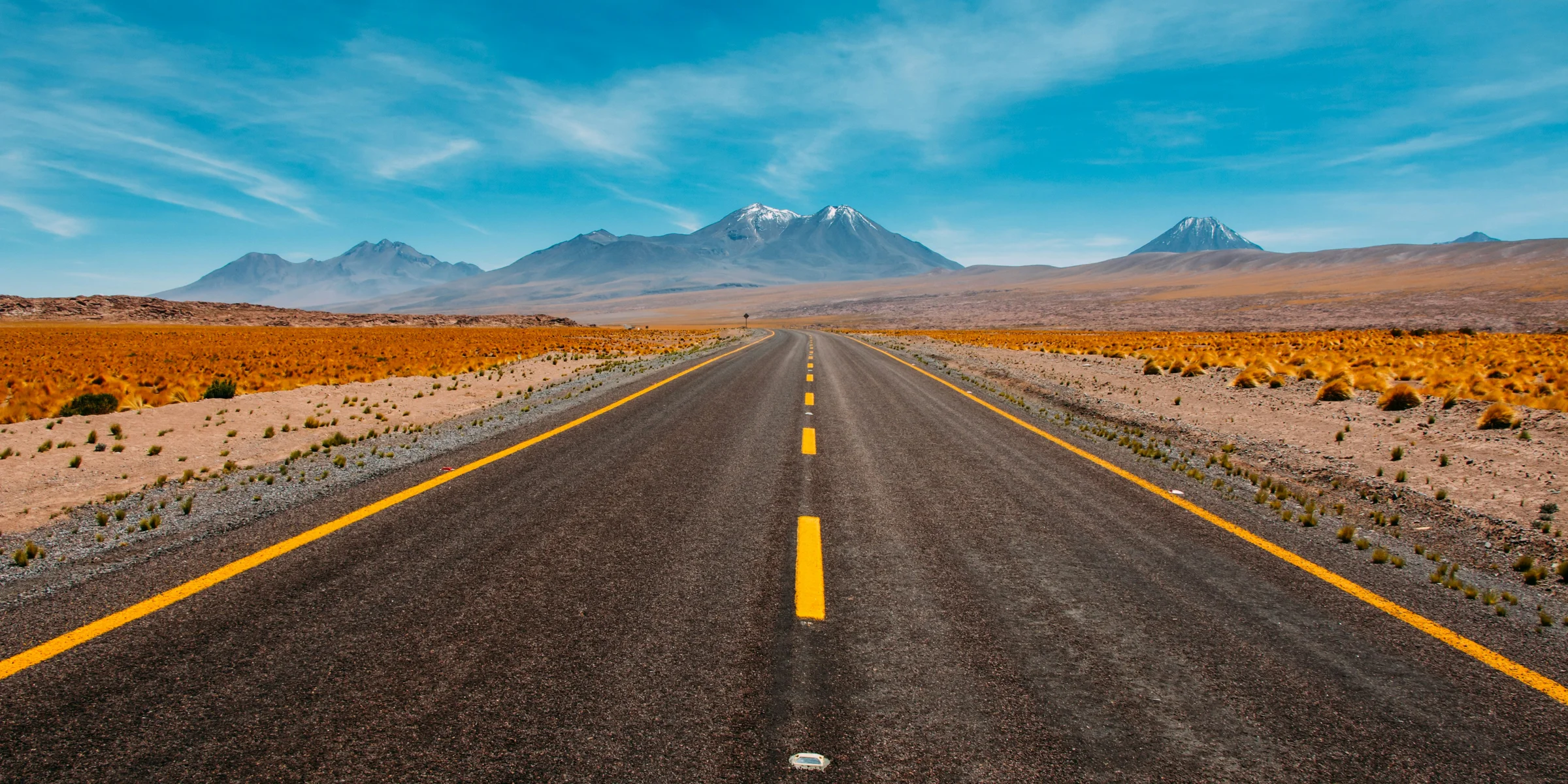 lone road going to mountains.
