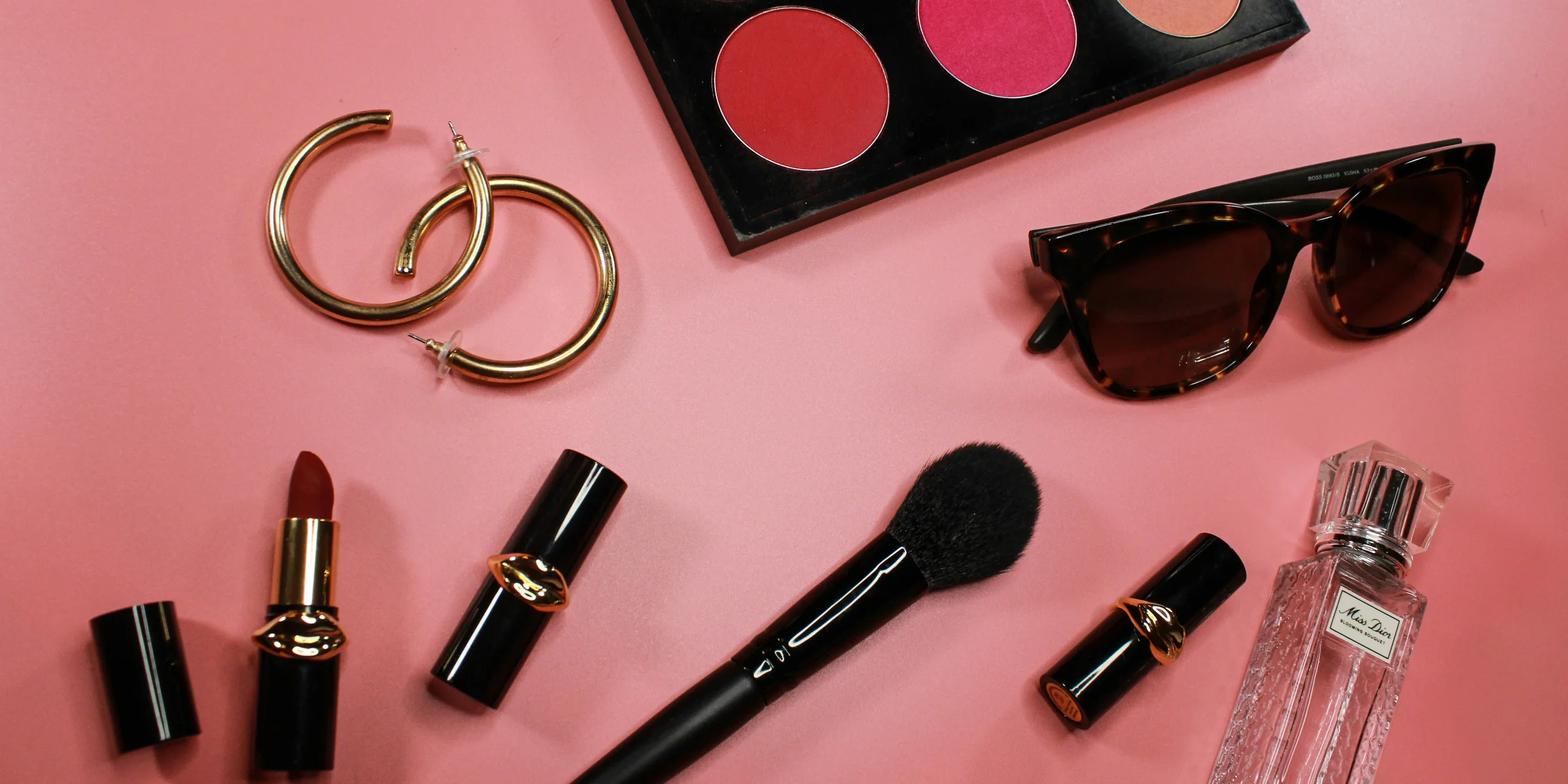 black and pink lipstick on pink surface