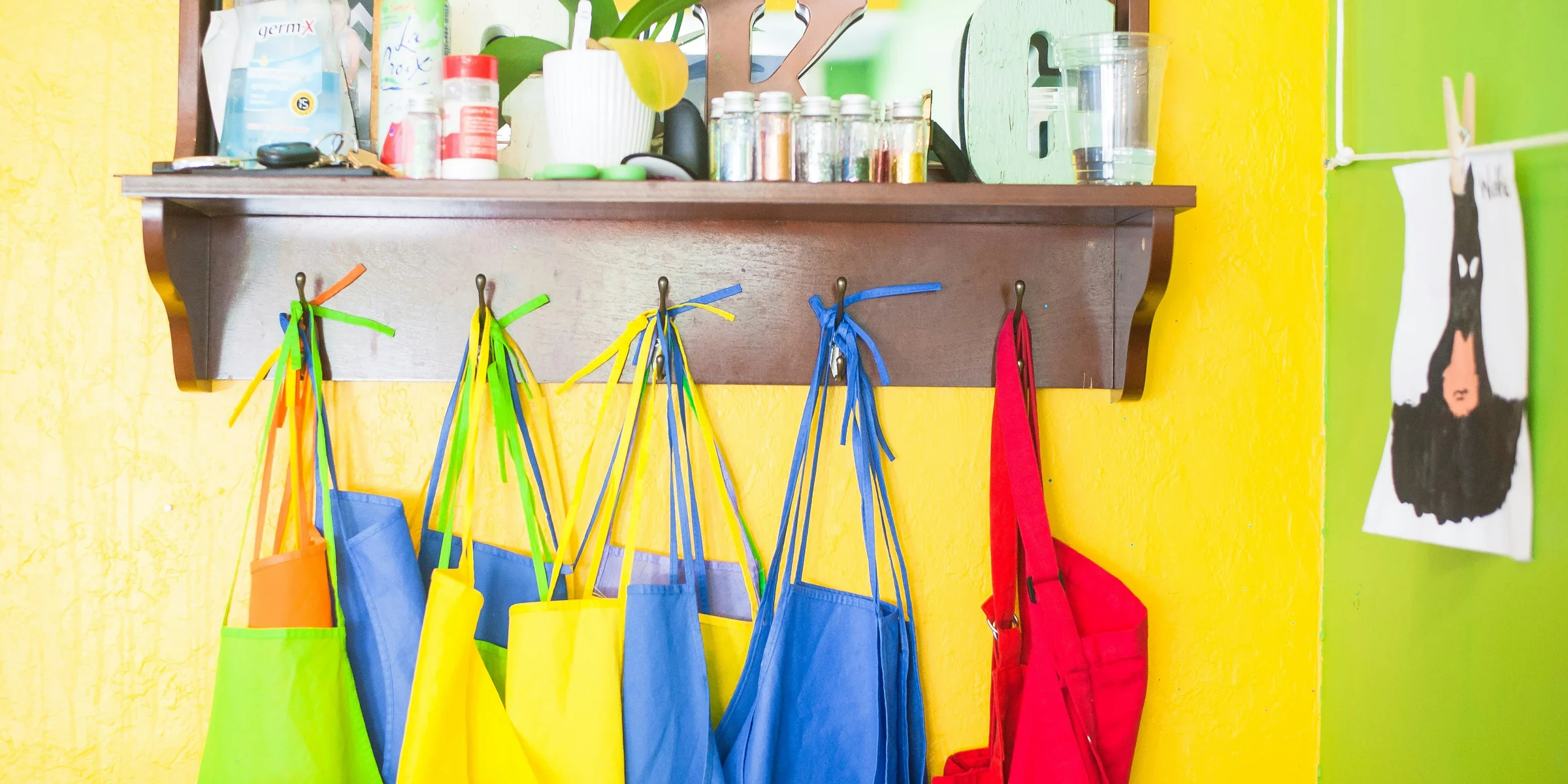 assorted-color bag lot hanging on brown wooden wall rack