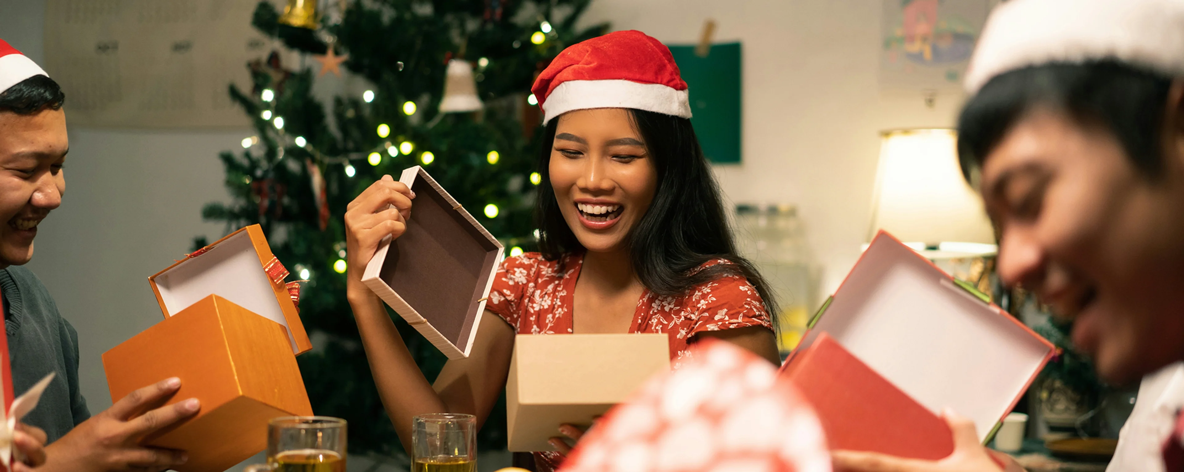 three friends opening christmas presents