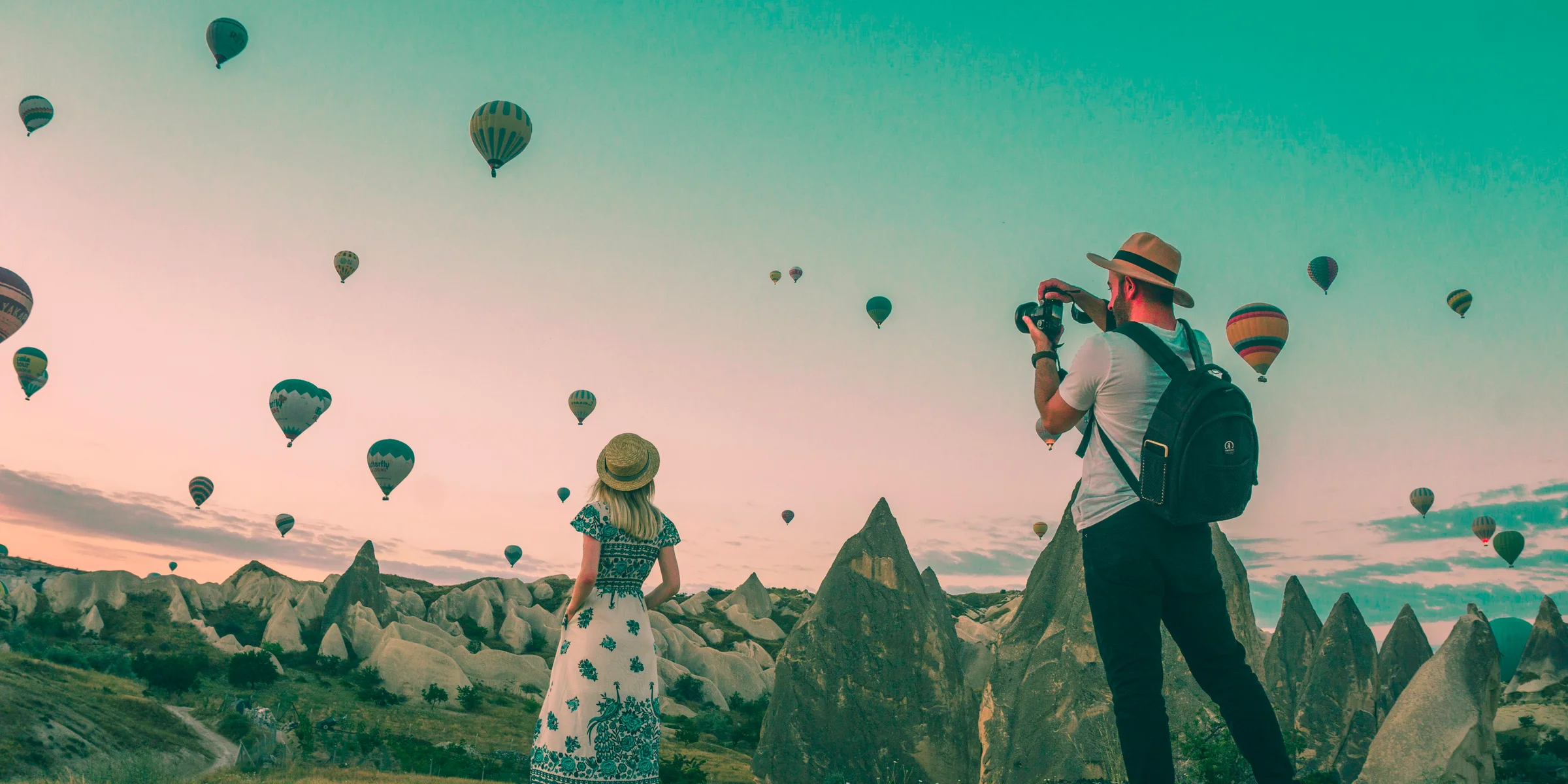 man taking photo of hot air balloons.