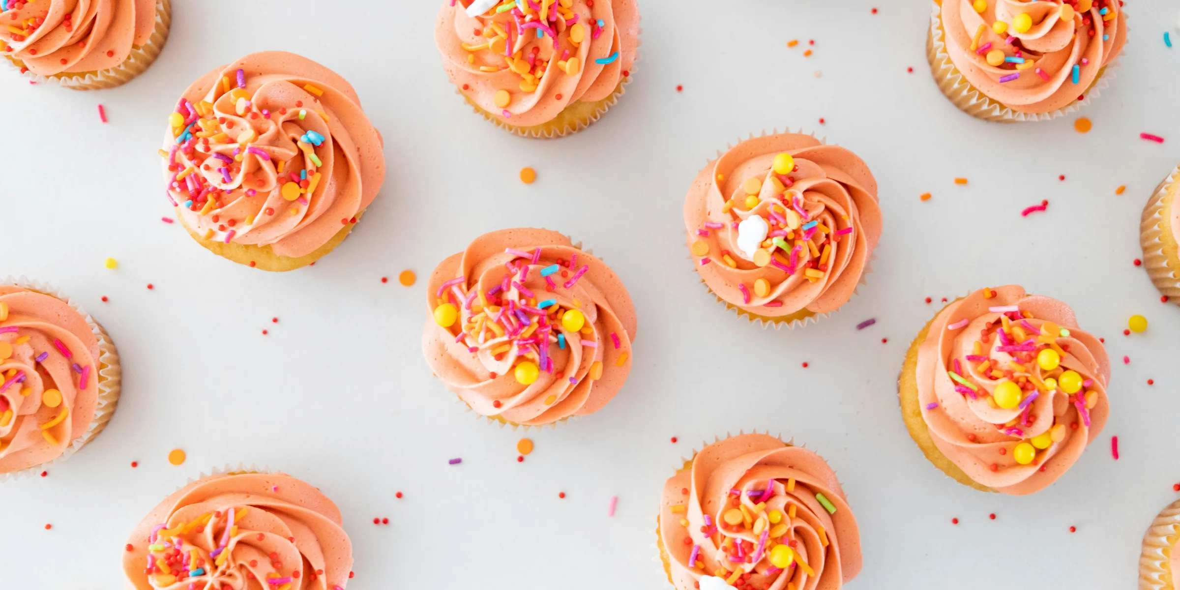 a table topped with lots of cupcakes covered in frosting.