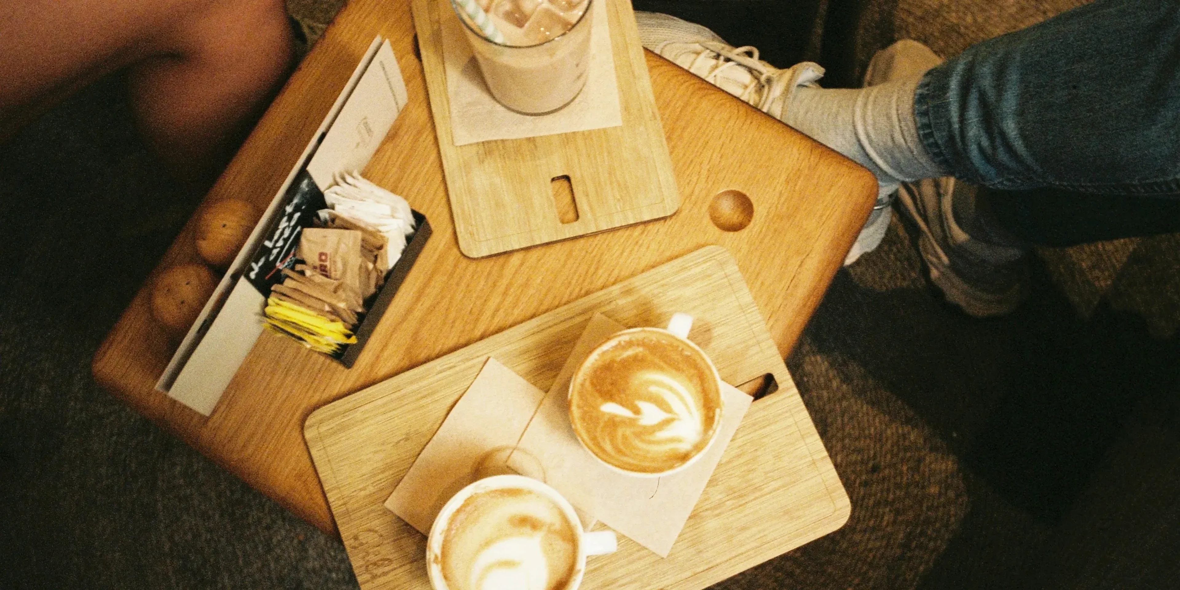 a person sitting at a table with two cups of coffee