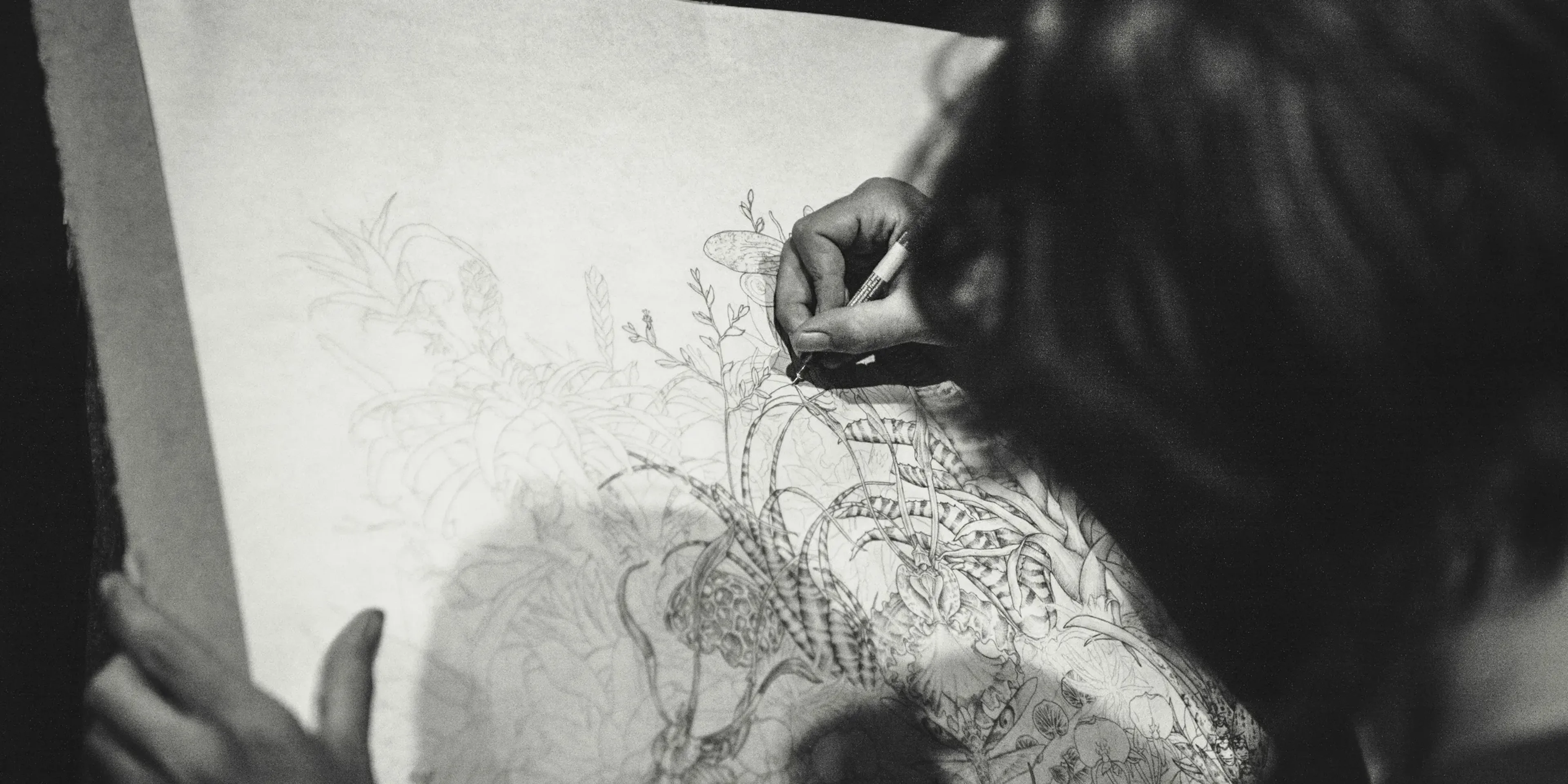 grayscale photo of a woman drawing a flowers