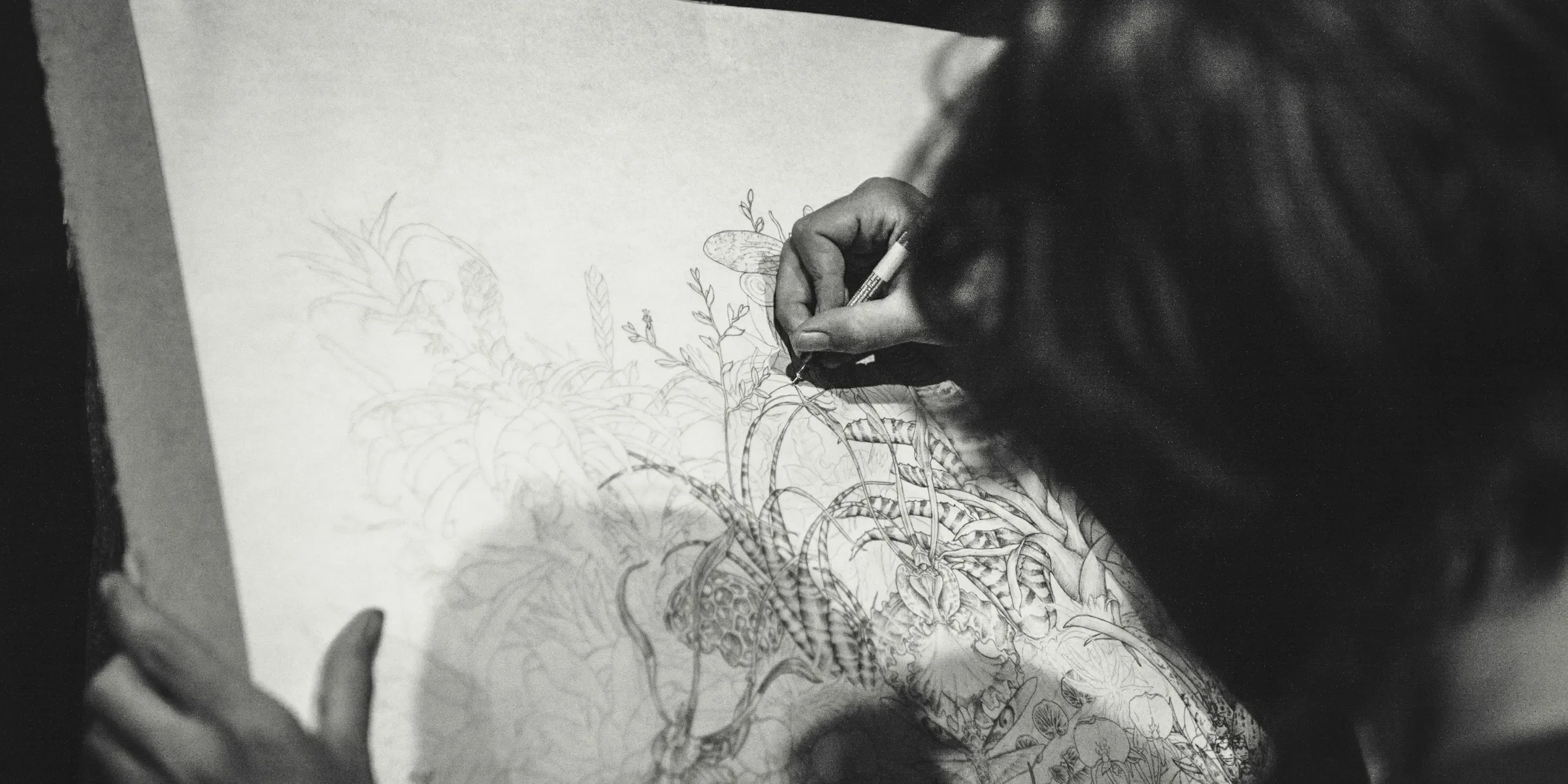grayscale photo of a woman drawing a flowers