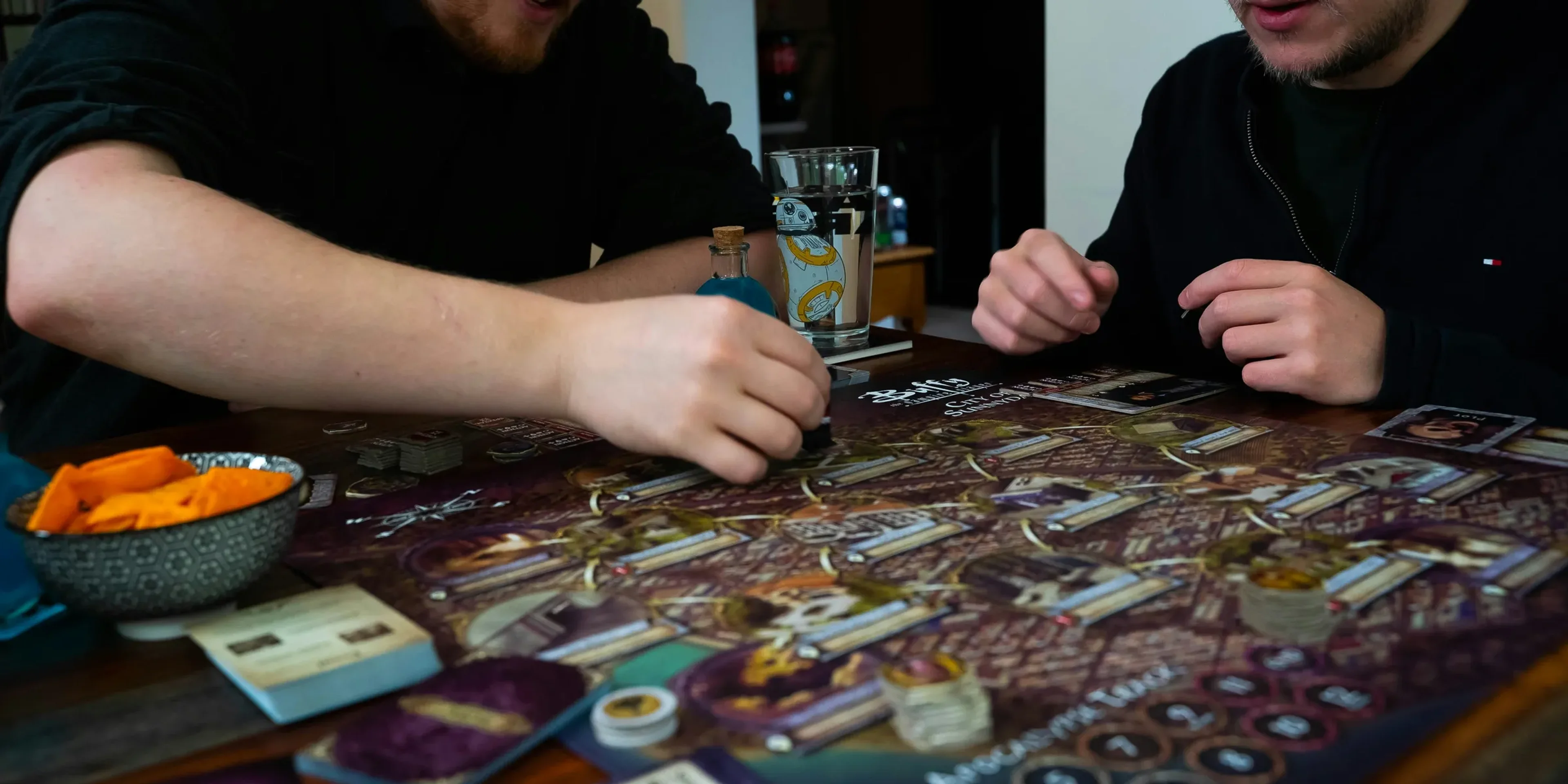 two men sitting at a table playing a board game