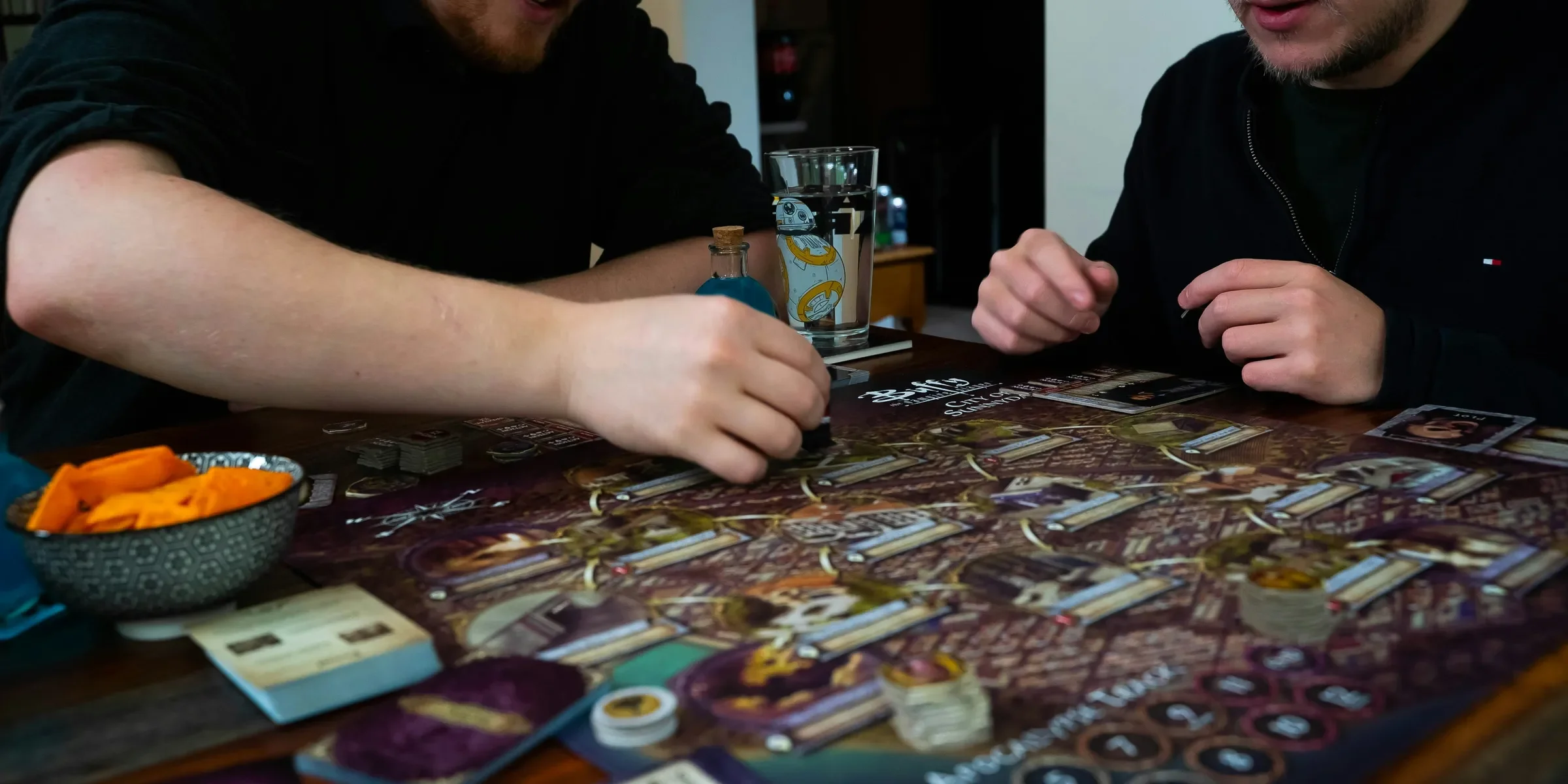 two men sitting at a table playing a board game