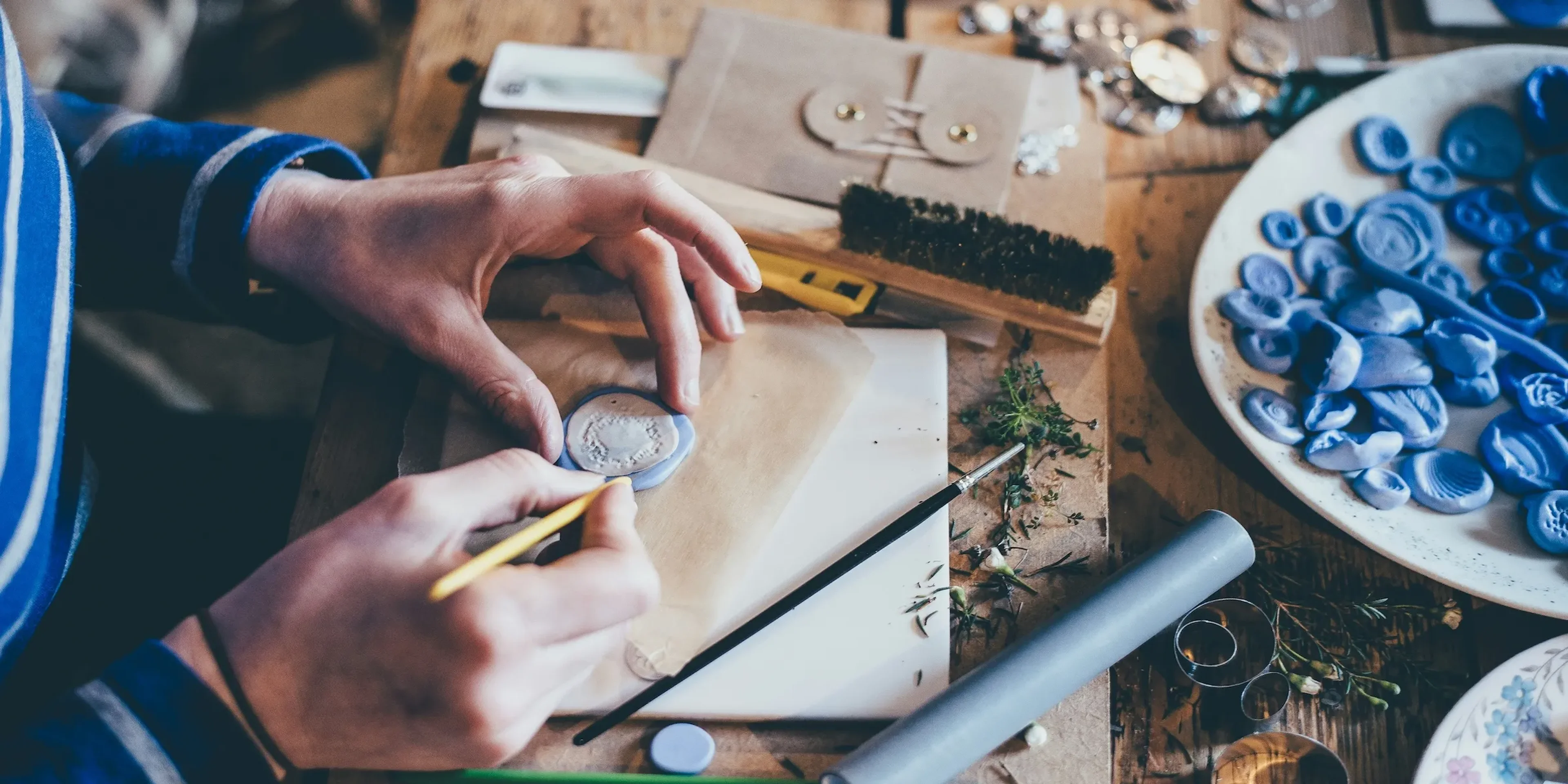 person making little clay objects