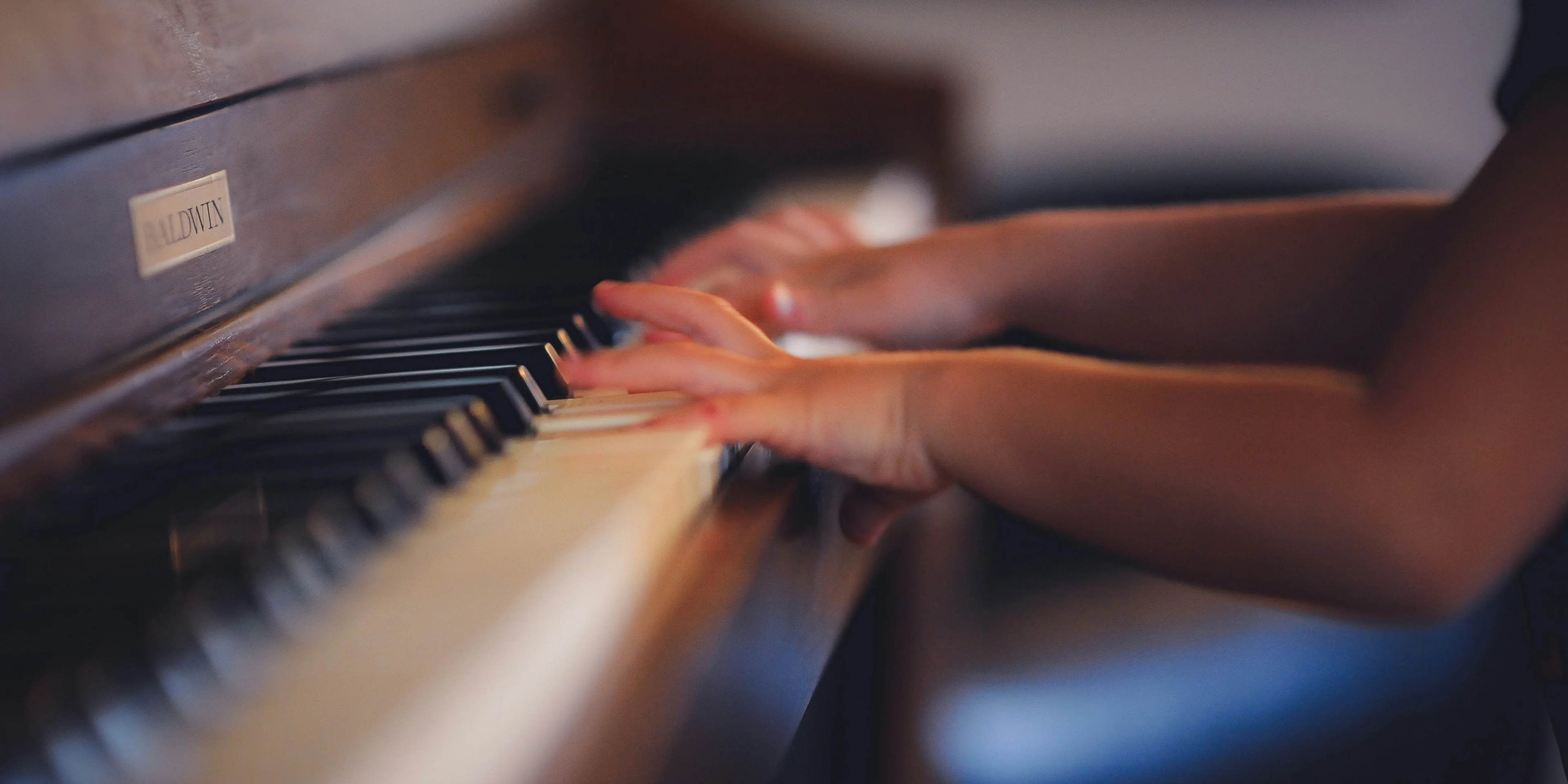 person playing upright piano.
